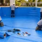 Técnico ajustando revestimento de vinil em piscina residencial no Jardim dos Eucaliptos, Aparecida de Goiânia