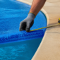 Técnico mede capa térmica azul sobre piscina antes do ajuste em Nova Iguaçu de Goiás