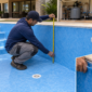 Técnico medindo a profundidade de uma piscina de vinil junto ao ralo, retorno e casa de máquinas