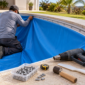 Técnico ajustando revestimento de vinil azul no trilho de uma piscina durante a troca do bolsão