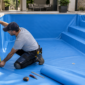 Técnico medindo o revestimento vinílico de uma piscina vazia no Jardim das Palmeiras Oeste